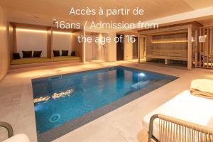 a swimming pool in a house with a room with a bed at Hôtel Terra Vinum in Gueberschwihr