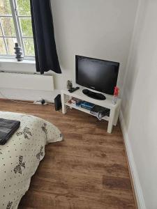 a living room with a television on a white table at Newly Renovated Studio in Bishop's Stortford in Bishops Stortford