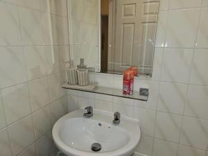 a white bathroom with a sink and a mirror at Newly Renovated Studio in Bishop's Stortford in Bishops Stortford