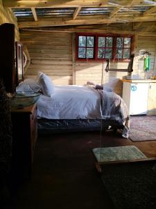 a bedroom with a bed in a log cabin at Tree house Living in Roodepoort