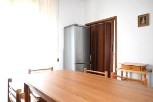 a kitchen with a table and a refrigerator at SE274 - Marotta, ampio quadrilocale con posto auto in Marotta +16 photos