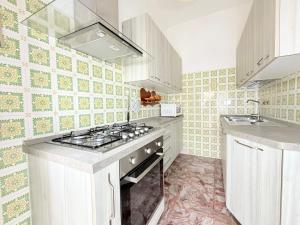 a kitchen with a stove top oven next to a sink at SE274 - Marotta, ampio quadrilocale con posto auto in Marotta