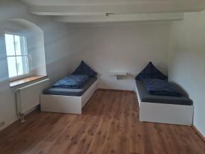 two beds in a room with wooden floors at Unseburger Brauhaus - FW7 in Unseburg