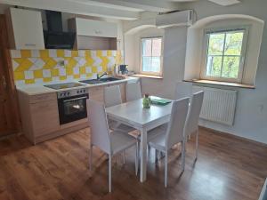 a kitchen with a table and chairs and a stove at Unseburger Brauhaus - FW7 in Unseburg