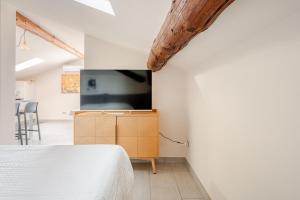 a bedroom with a bed and a tv on a wall at Lake View - Gardone Center - Private Garage in Gardone Riviera