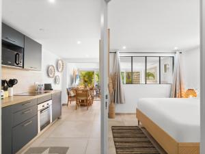 a kitchen and living room with a bed and a table at Shell Beach Splendide 2 chambres sur la plage in Baie Nettle