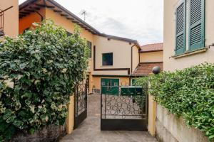 an entrance to a house with a gate and bushes at Lake View - Gardone Center - Private Garage in Gardone Riviera