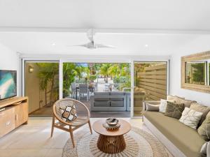 a living room with a couch and a table at Shell Beach Splendide 2 chambres sur la plage in Baie Nettle