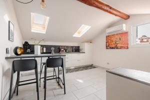 a kitchen with a counter and stools in a room at Lake View - Gardone Center - Private Garage in Gardone Riviera