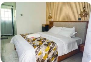 a hotel room with a large bed with white sheets at Omtush Suites 002 in Marimbeti