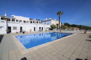 a large swimming pool in front of a white house at Charming Vila Van Gogh in Luz