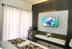 a hotel room with a television on a wall at Omtush Suites 002 in Marimbeti +4 photos