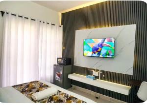 a hotel room with a television on a wall at Omtush Suites 002 in Marimbeti
