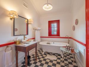 a bathroom with a tub and a sink and a mirror at Tintswalo Summer House in Glencairn
