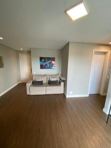a room with a couch and a tv on the wall at Flat - Excelente localização e vista espetacular in São José dos Campos