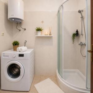 a bathroom with a washing machine and a shower at Inter-nautika doo in Jezera