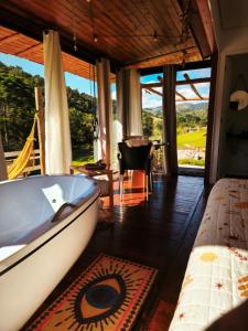 a bathroom with a tub in a room with a view at Chalés Recanto dos Sonhos in Camanducaia