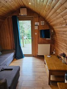 a living room with a couch and a table at Mountain Edge Resort Mega pod 5 with Hot Tub in Church Stretton