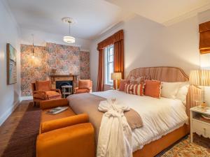 a bedroom with a large bed and a fireplace at Tintswalo Summer House in Glencairn