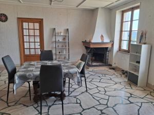 a room with a table and chairs and a fireplace at Le Picasso in La Chaise-Dieu