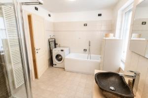 a bathroom with a sink and a washing machine at Appartamento Rio Duron by AMA Val di Fassa in Campitello di Fassa