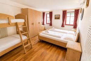 a bedroom with two bunk beds and a ladder at Appartamento Rio Duron by AMA Val di Fassa in Campitello di Fassa