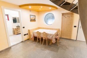 a dining room with a table and a bathroom at Appartamento Rio Duron by AMA Val di Fassa in Campitello di Fassa