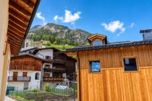 a wooden house with a mountain in the background at Appartamento Rio Duron by AMA Val di Fassa in Campitello di Fassa