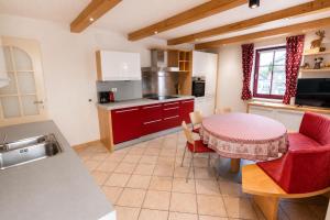 a kitchen with a table and red chairs in a room at Appartamento Rio Duron by AMA Val di Fassa in Campitello di Fassa +5 photos