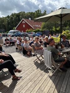 a crowd of people sitting in chairs on a deck at Smedjan affären in Varberg