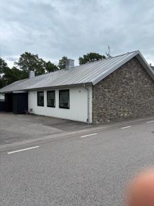 a building with a stone wall and a building with windows at Smedjan affären in Varberg