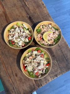 three bowls of food on a wooden table at Smedjan affären in Varberg