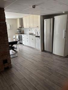 a kitchen with a refrigerator and a table in it at Smedjan affären in Varberg