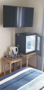 a room with a table with a tv and a table sidx sidx at La terrasse des oiseaux in Taillet