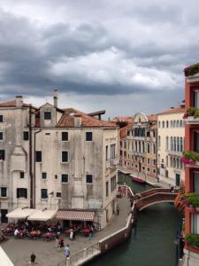 eine Brücke über einen Fluss in einer Stadt mit Gebäuden in der Unterkunft Ca' Dei Polo in Venedig