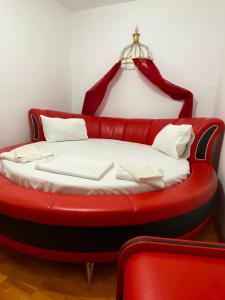 a red bed in a room with a red couch at Hotel Dona in Mamaia +1 photo