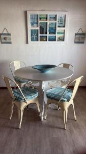 a dining table with two chairs and a table and two windows at Sundowner in Yzerfontein