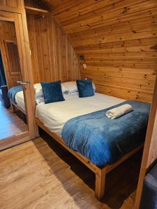 a bedroom with a bed in a wooden cabin at Mountain Edge Resort Mega pod 1 with Hot Tub in Church Stretton