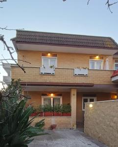 a brick house with white windows and plants at Guest house - L'amante e il marinaio in Fiumicino