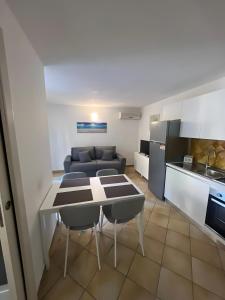 a kitchen and living room with a table and a couch at Residence Orizzonti app n 3 in Golfo Aranci