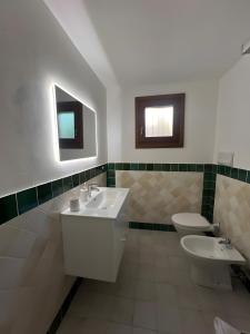 a bathroom with two toilets and a sink and mirrors at Residence Orizzonti app n 3 in Golfo Aranci