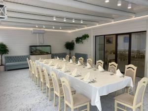 a long white table and chairs in a room at versal in Ternopil