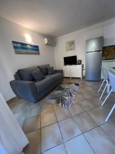 a living room with a couch and a refrigerator at Residence Orizzonti app n 3 in Golfo Aranci +11 photos