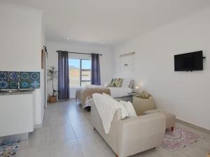 a living room with a bed and a couch at Blouberg Studio Apartments in Cape Town