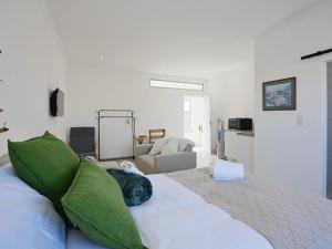 a bedroom with a large bed with green pillows at Blouberg Studio Apartments in Cape Town +38 photos
