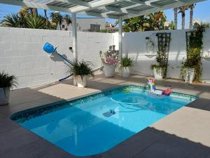 a swimming pool in a backyard with a toy at Blouberg Studio Apartments in Cape Town