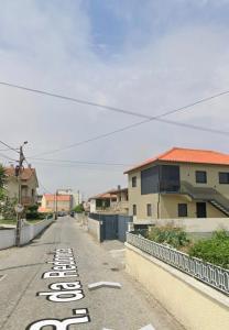 an empty street with a house and a street sign at Casa Fermar in Esposende