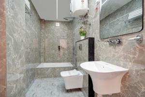 a bathroom with a sink and a toilet at The Grand Olive Aero Suites Near Delhi Airport in New Delhi