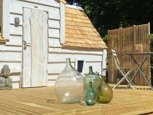 a group of four glass vases sitting on a wooden deck at Cabane Forest in Villaines-la-Gonais +8 photos