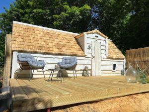 a dog house with two chairs on a wooden deck at Cabane Forest in Villaines-la-Gonais